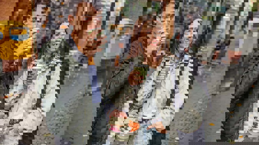 två unga personer dricker ur pappersmuggar