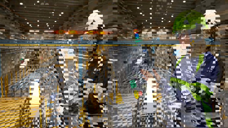 industriarbetare står vid datorskärm